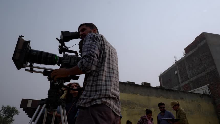 A person is filming a scene with a camera