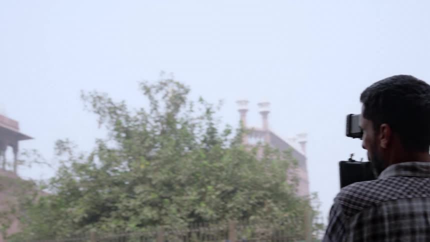 A person is filming a scene with a camera