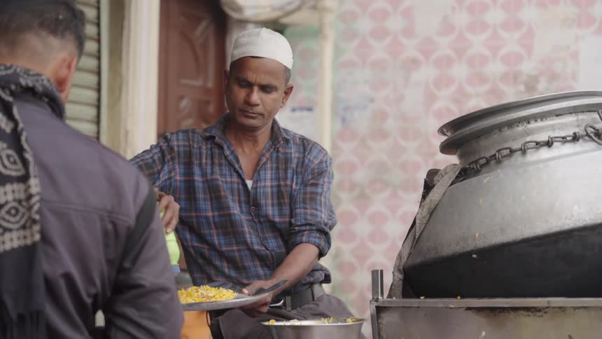 Man in an outdoor setting serving a plate of food