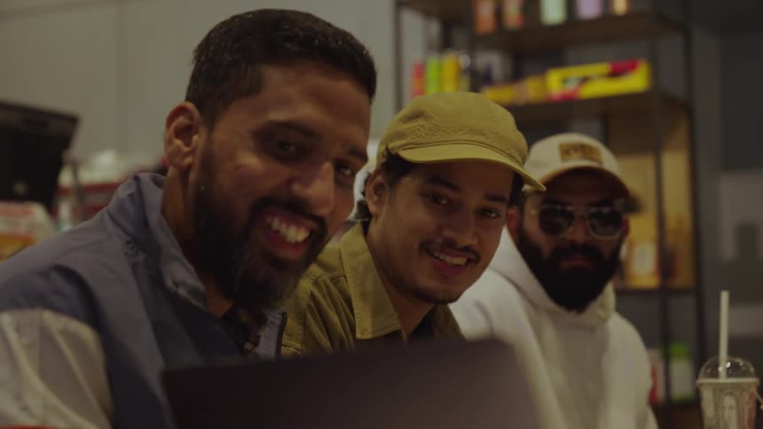 Three men looking at a screen in a store