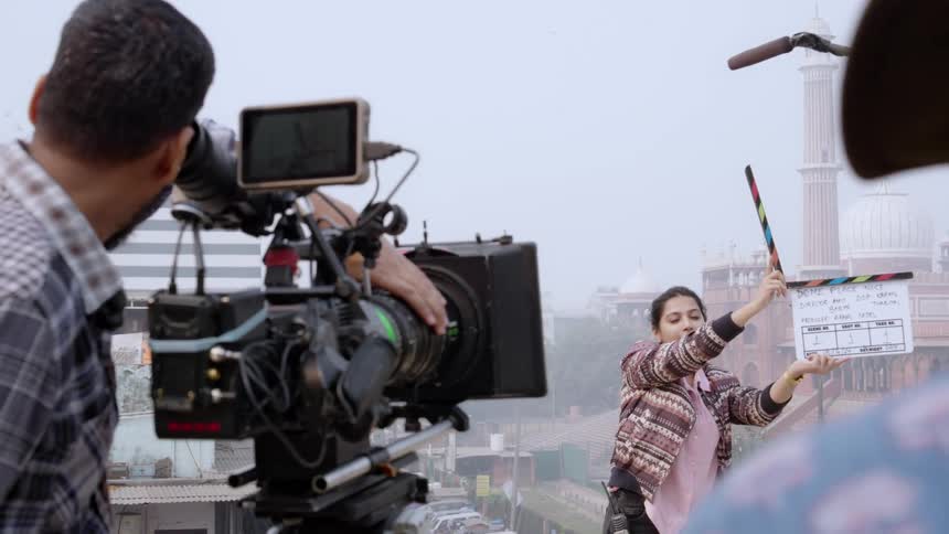 A group of people are filming in a city