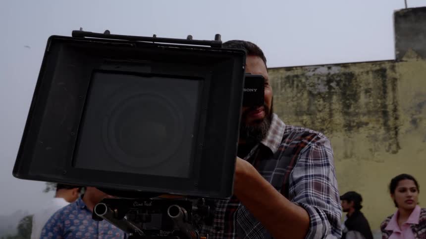 A man is filming with a large camera