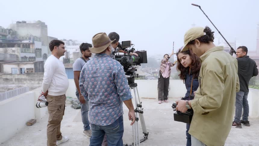A film crew are working on the roof