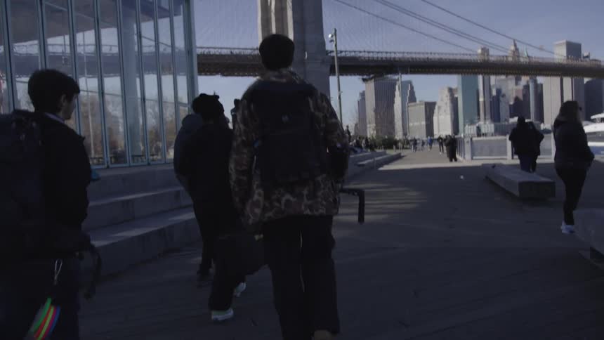 Group of people with equipment and backpacks walking through the city outdoors