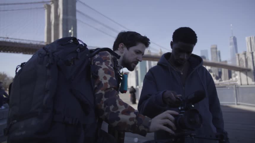 A cameraman showing a young man how to use the camera