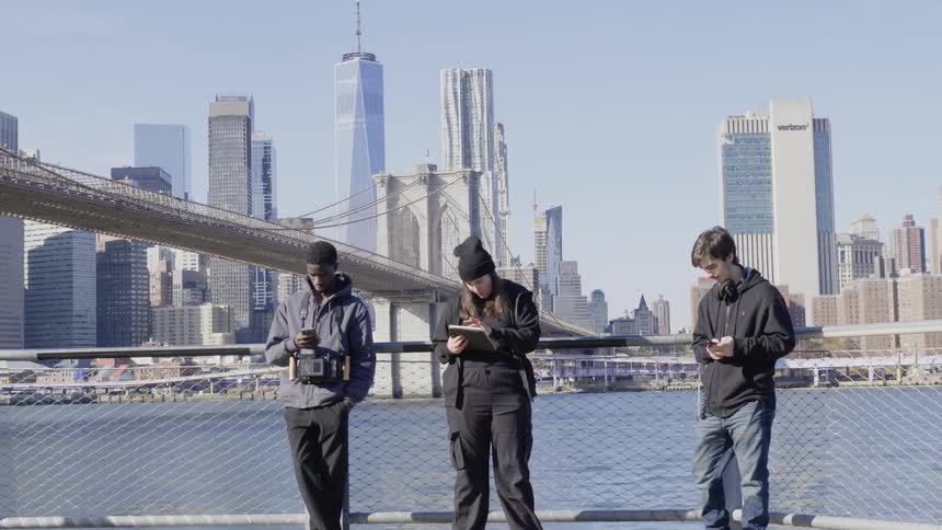 Teenagers are using their devices by the bridge