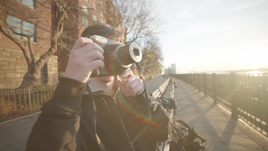 Man taking a photograph with a professional camera and developing a photo instantly