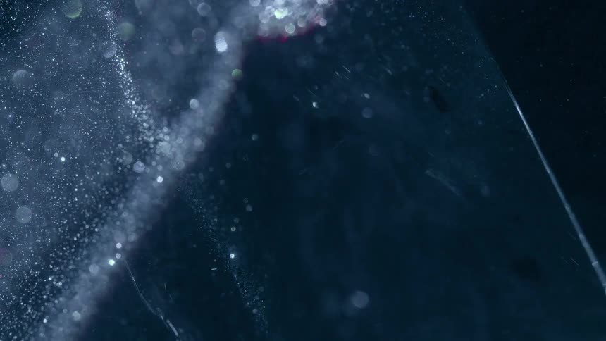 Light reflects off a surface revealing a shimmering texture as it moves across