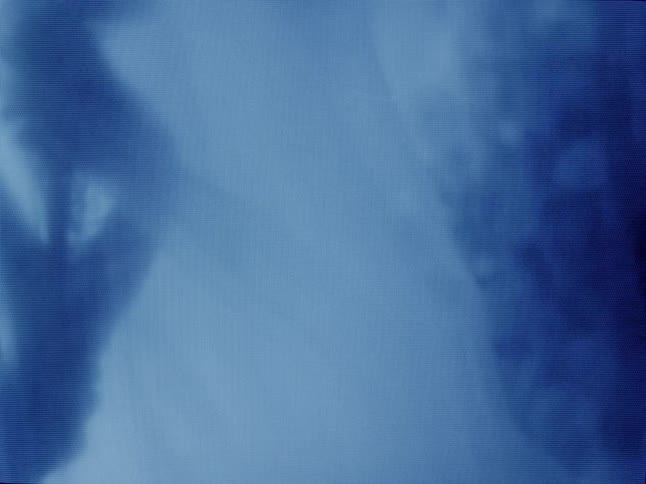 Silhouette of a person against a curtain