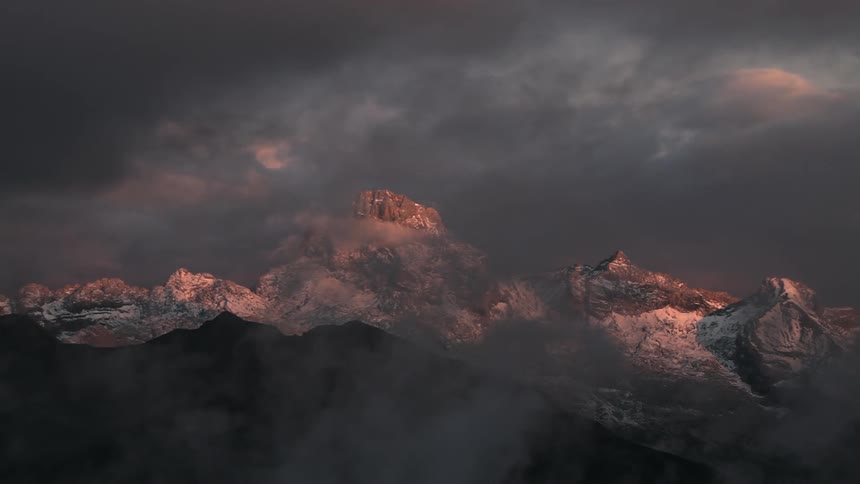Dark clouds are moving across a mountain peak
