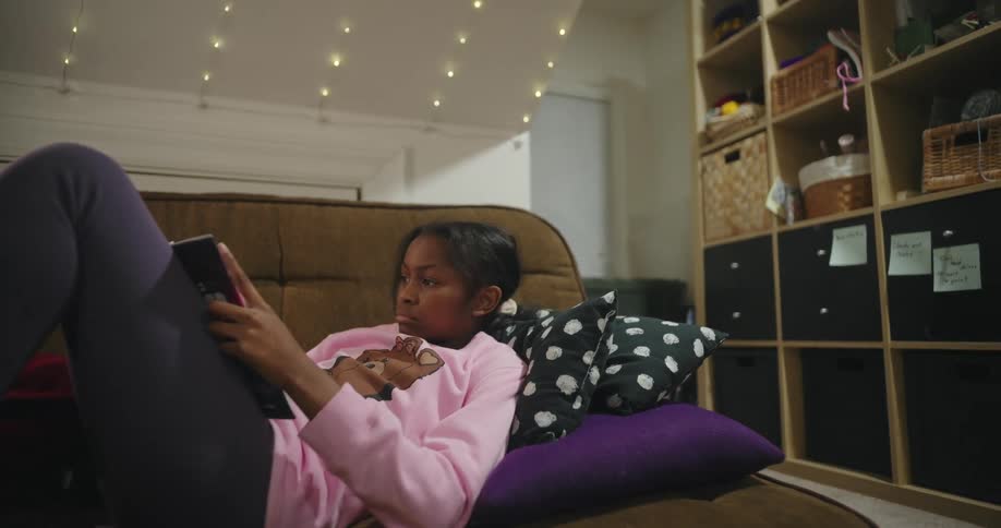 Girl lying on a sofa reading a book