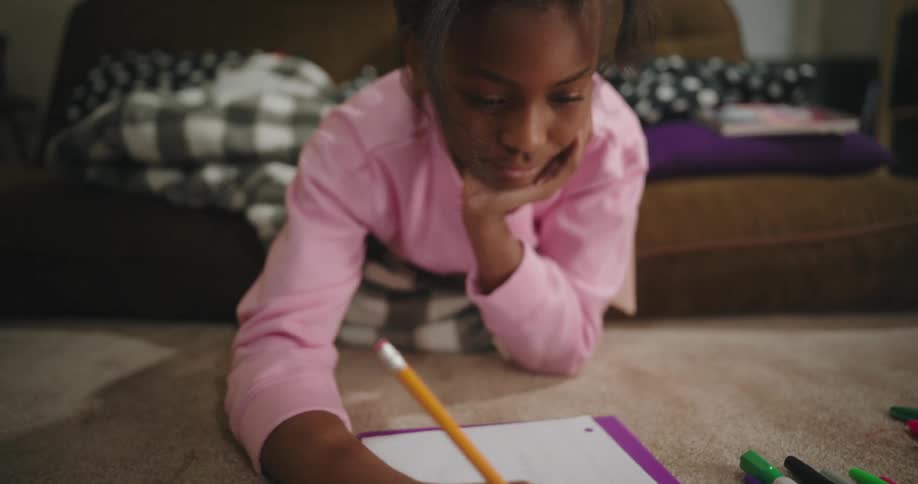 A child is drawing with a pencil