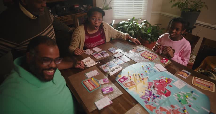 Family having fun around the table playing a board game