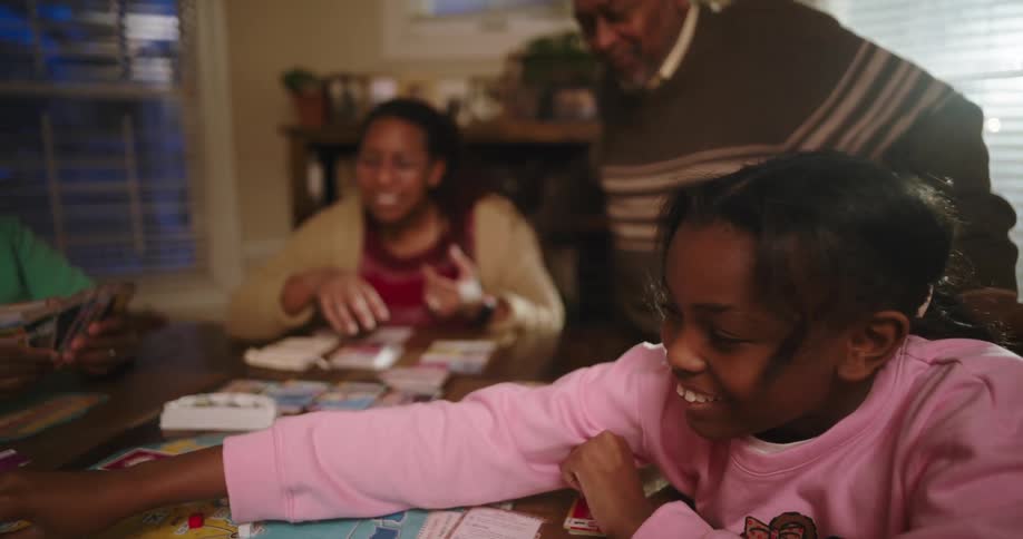 Family gathered at a table playing board game