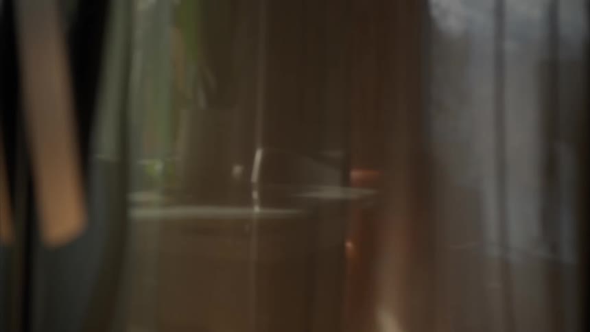 A person can be seen through the curtains walking outside
