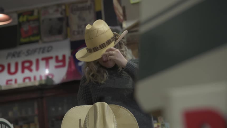 Customers in the store try on cowboy hats
