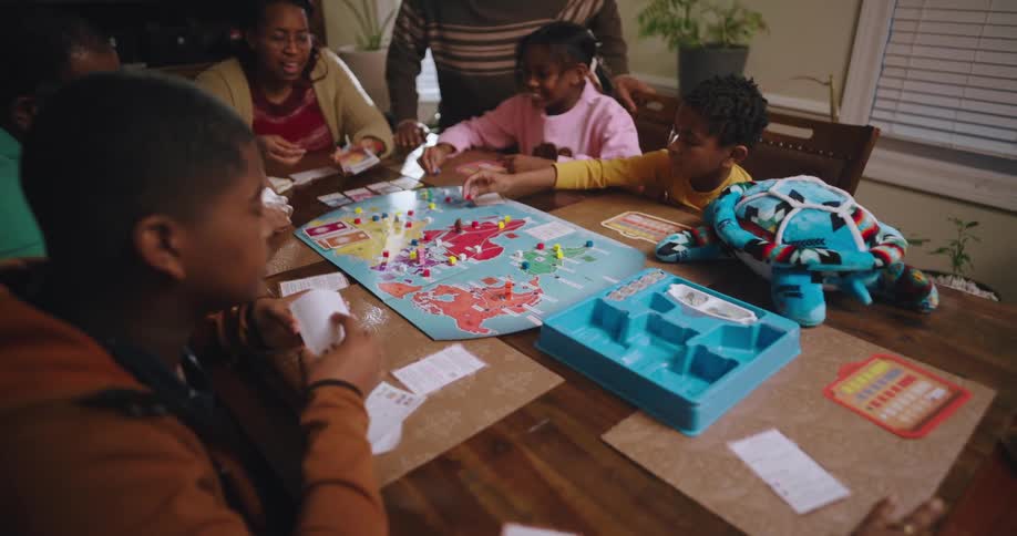 Family plays a board game with visiting grandparents