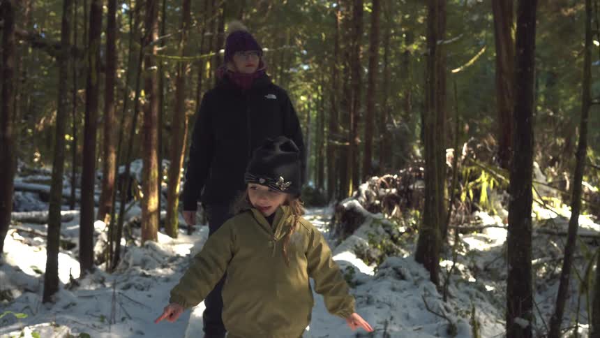 A mother and her child hike through the forest