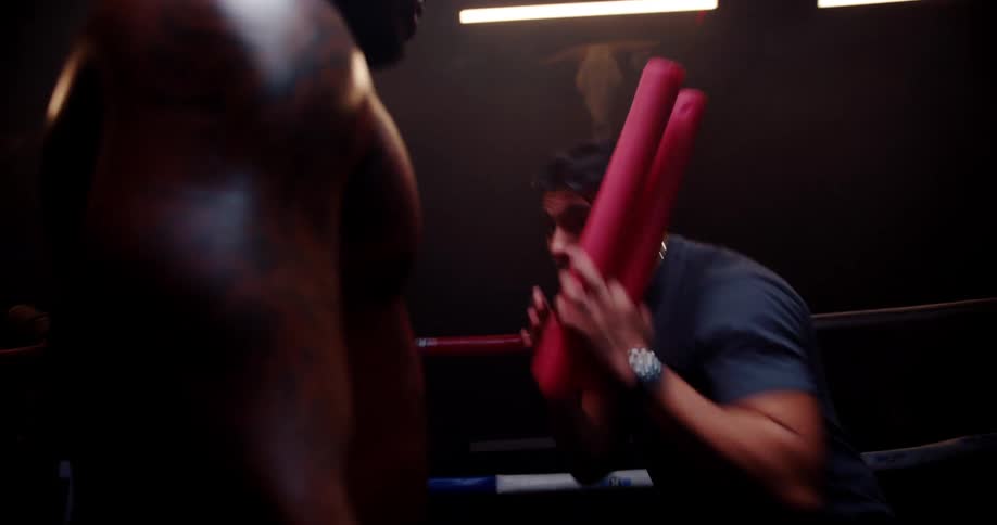 Two men in a boxing ring doing training