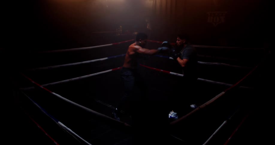 Two boxers are sparring in the ring