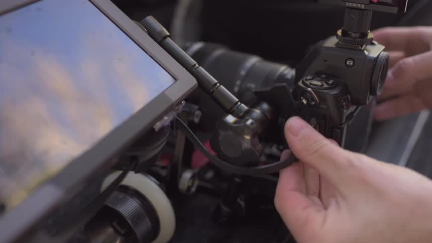 A photographer plugs a usb cord into a camera