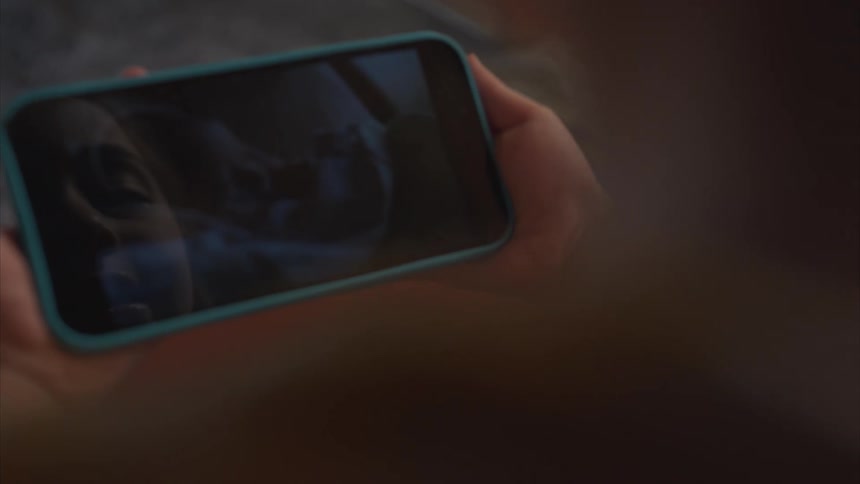 A person is watching a video of a baby on their cell phone
