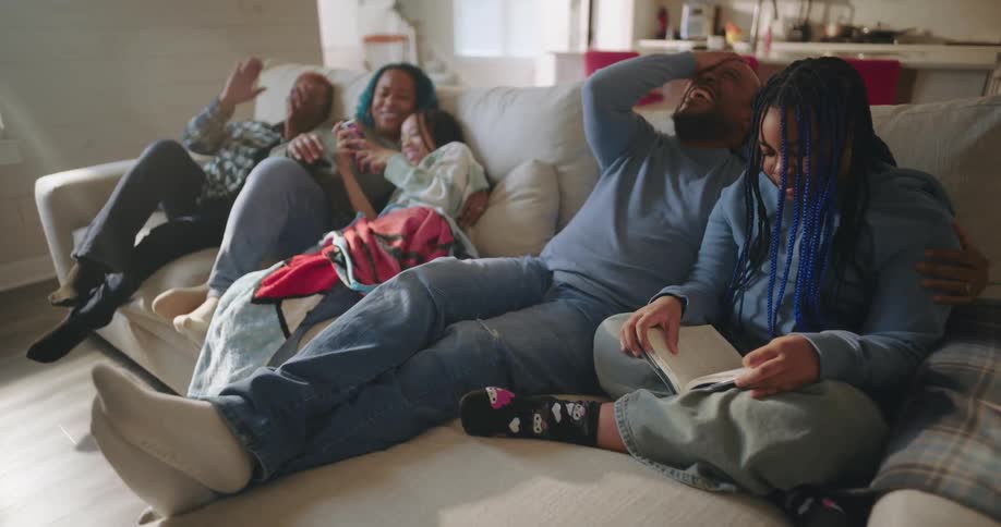 A family relaxing on the couch at home having a good time laughing