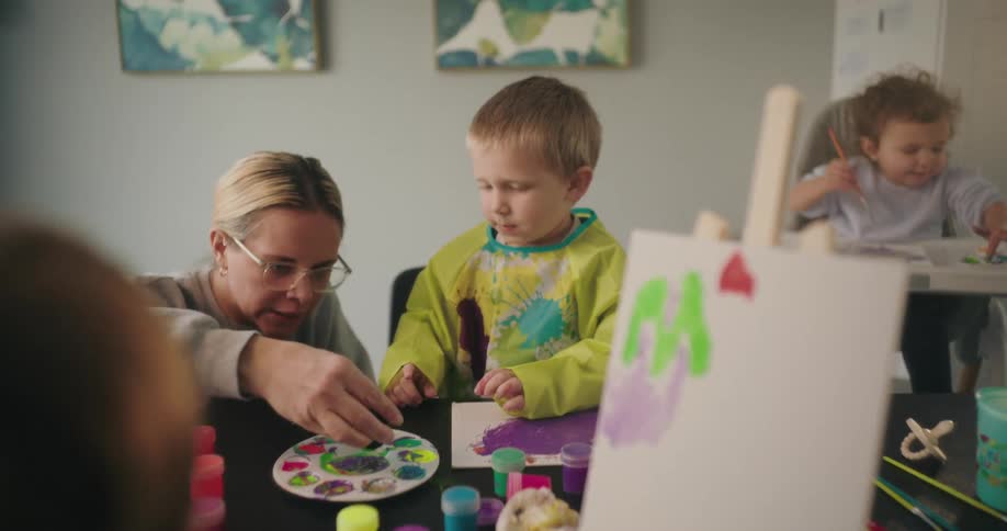 A mother helping her children with an art project