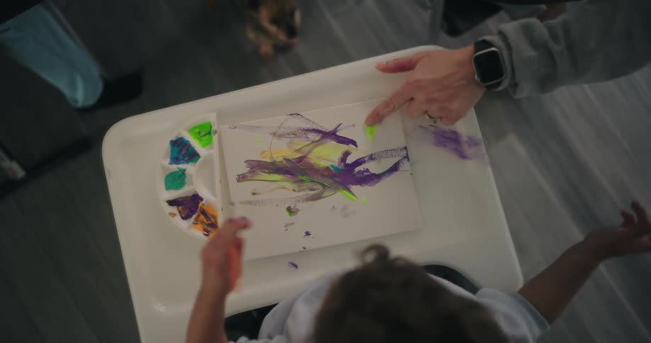 A child is painting with water paint