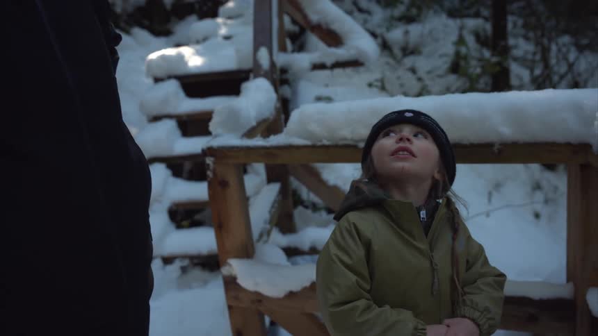 A child stands in the snow talking