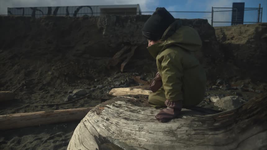 A child is talking on the log