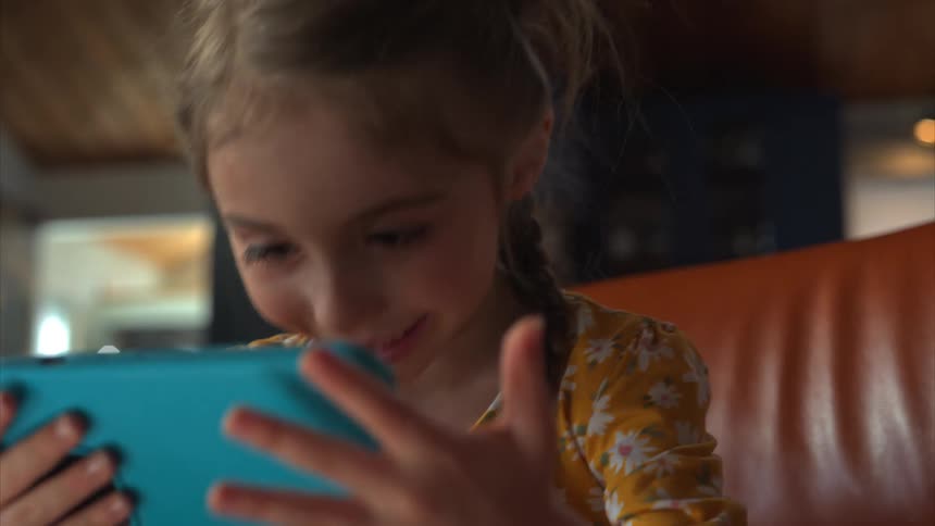 A girl is watching something on her cell phone