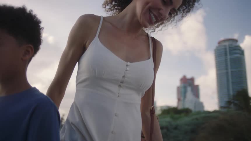 Smiling mother walking hand in hand with her children outdoors