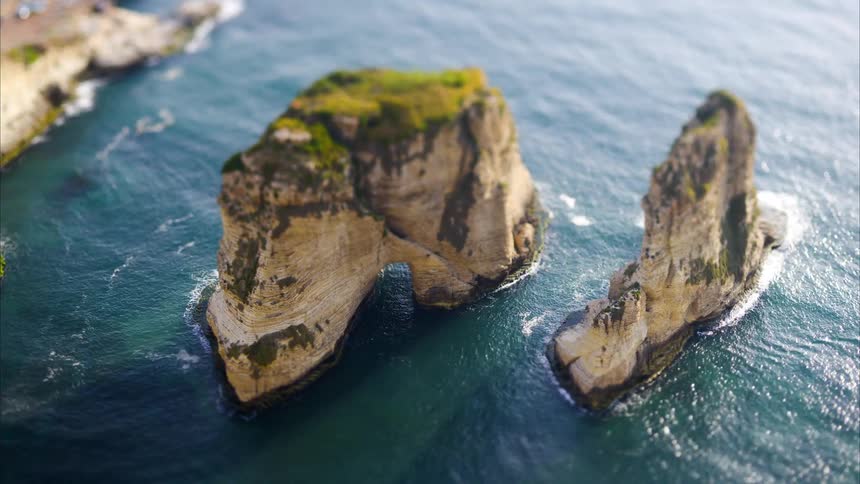 A clop of boat driving through some cliffs in the sea