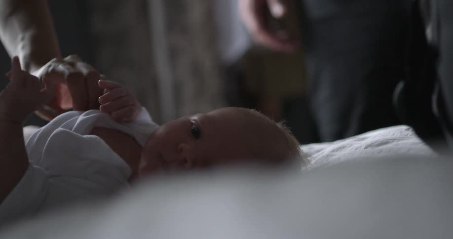 A baby lays on a blanket