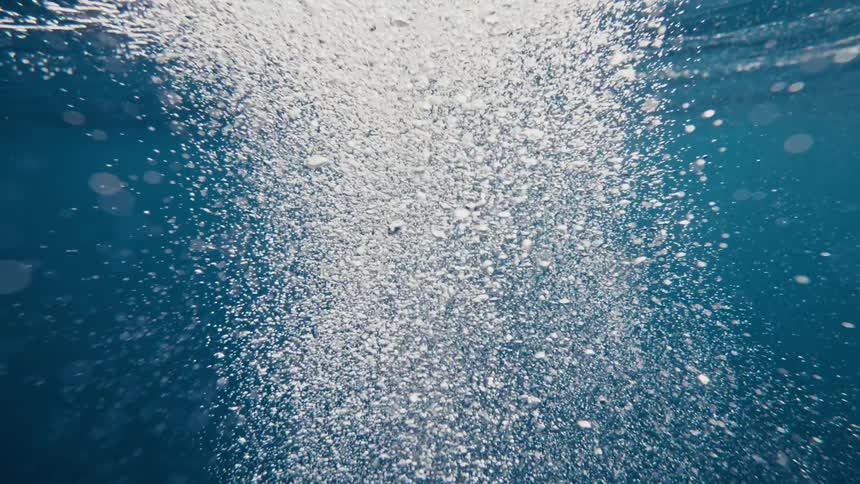 View from inside the ocean with air bubbles rising