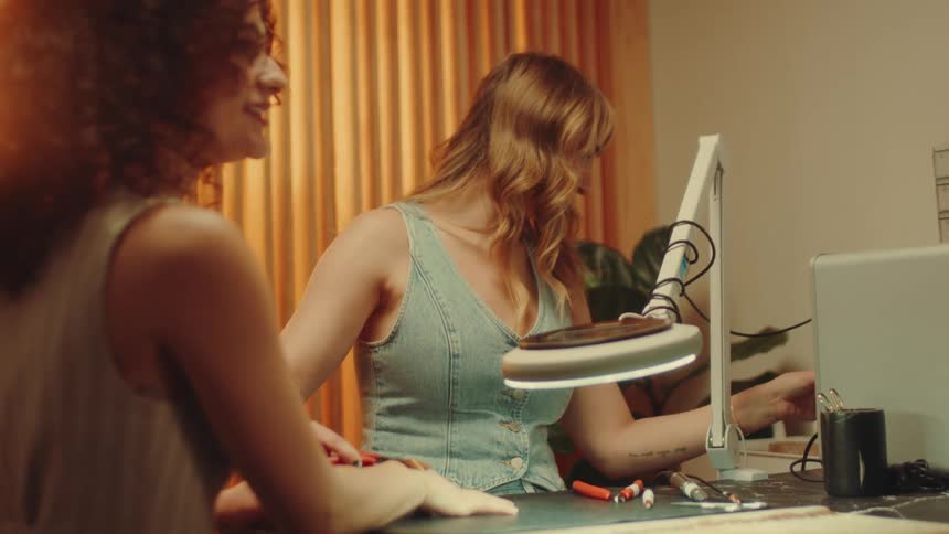 A woman is working while another talks