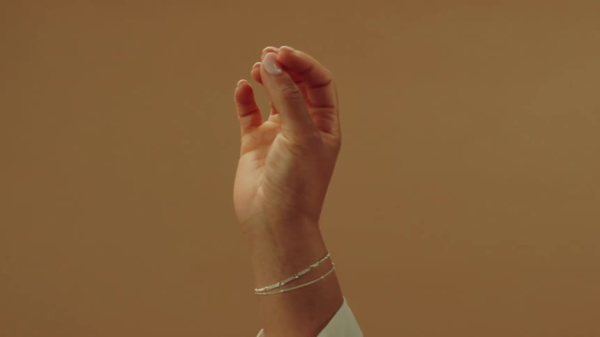 Woman rotates her hand in the air to display a delicate bracelet
