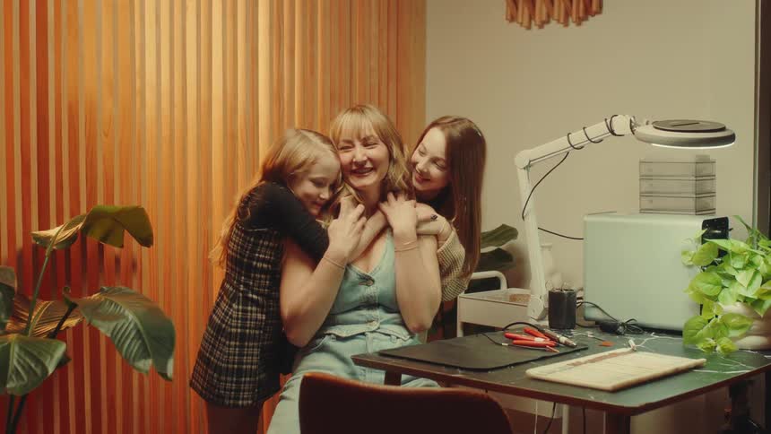 Two daughters hugging their mother affectionately