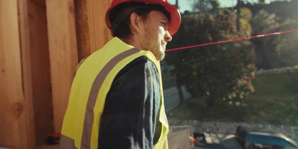 A construction worker walks by a home frame