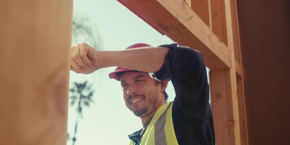 A man is hammering a nail into the frame