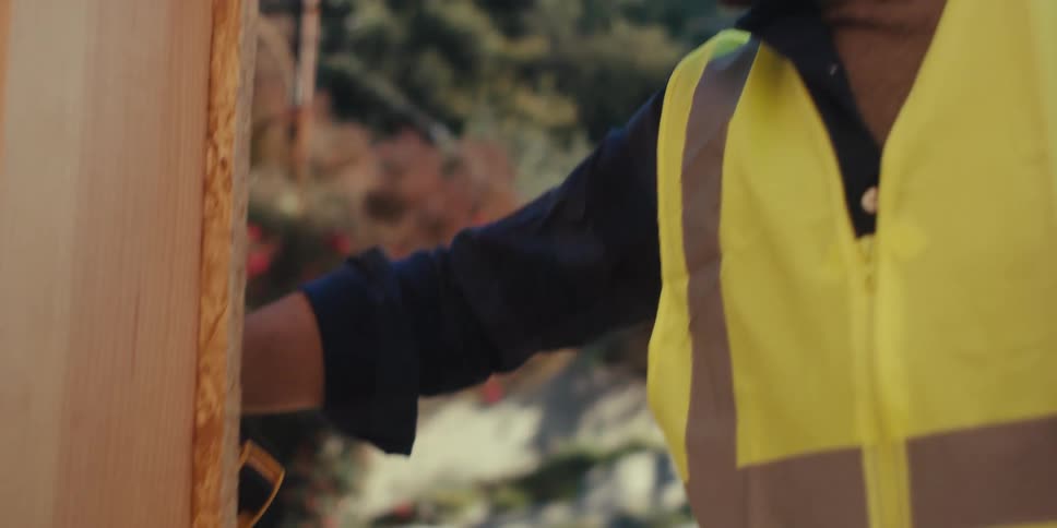 A construction worker is using measuring tape