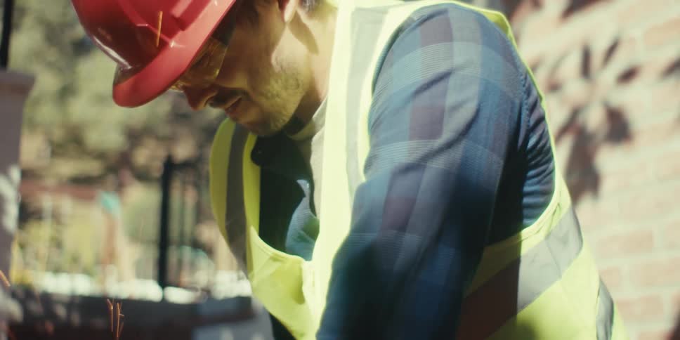 A construction worker is cutting rebar