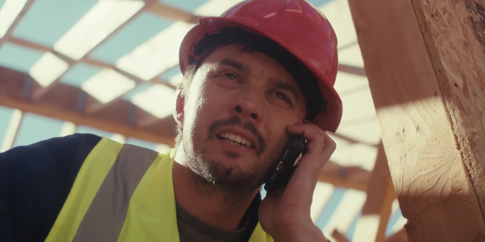 A construction worker talks on his cell phone
