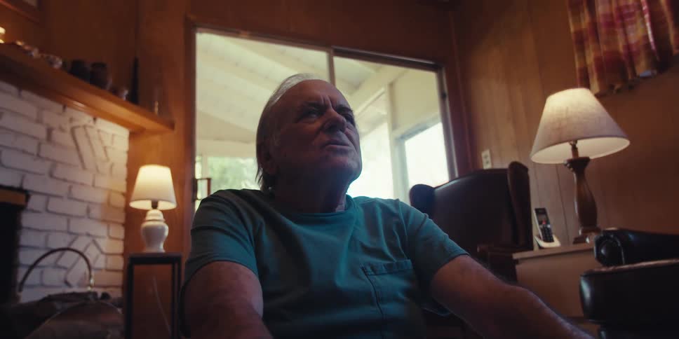 A man is meditating by the fireplace