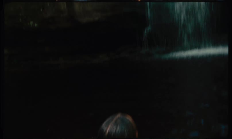 Woman in bikini swimming in a waterfall