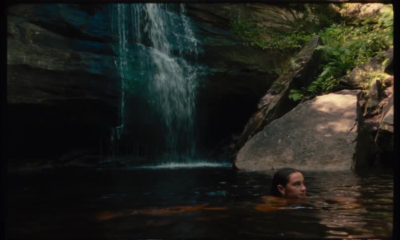 Teenage boy swimming in a waterfall