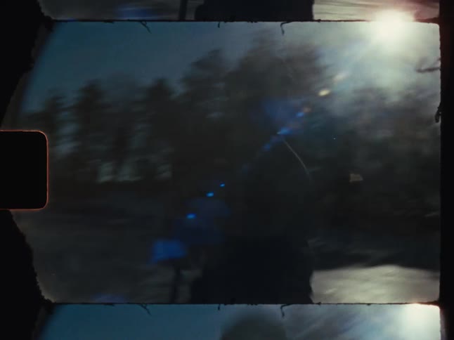 A person playing hockey on a frozen lake under the sun surrounded by a serene winter forest