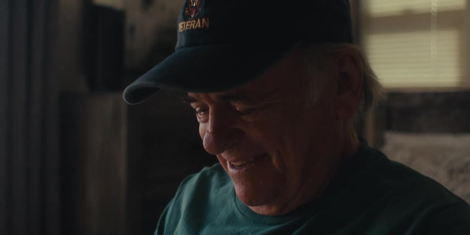 A man smiles while looking at his tablet
