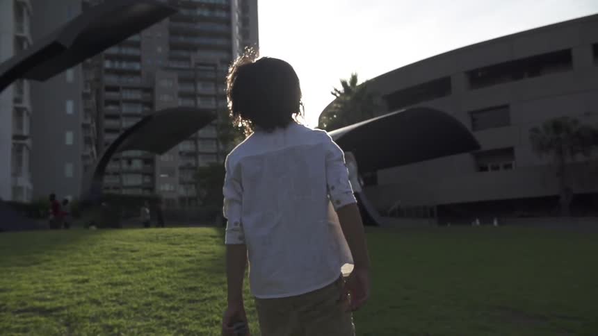Child walking through a yard in the city